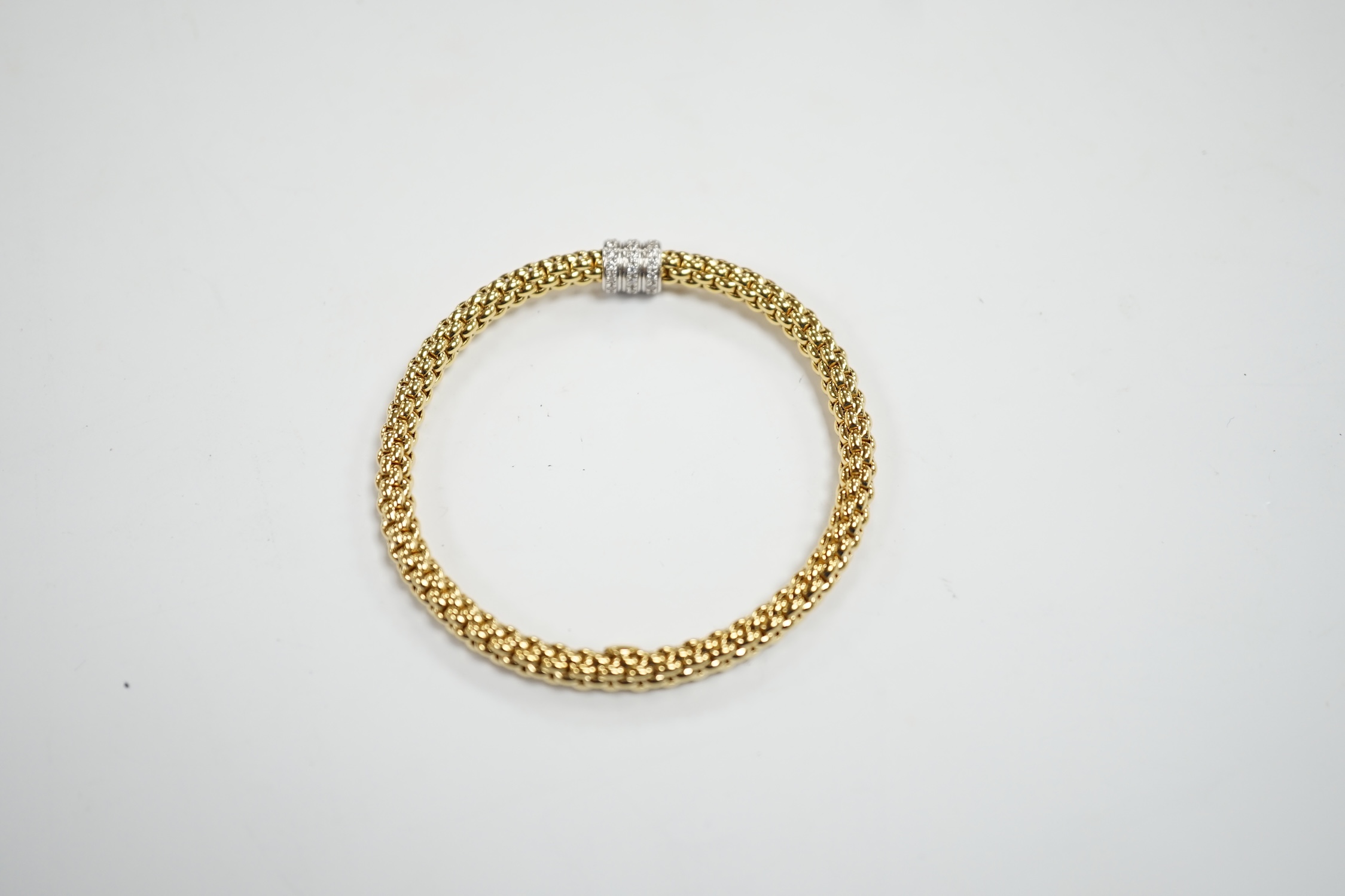 An Italian 18kt Fope flexible bracelet, with diamond chip set barrel shaped motif, gross weight 17.1 grams, with Fope box.